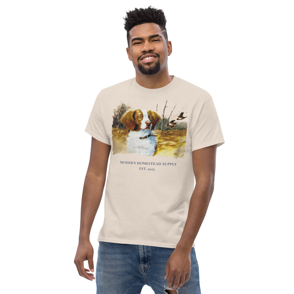 Man wearing a beige t-shirt with a graphic design on a white background