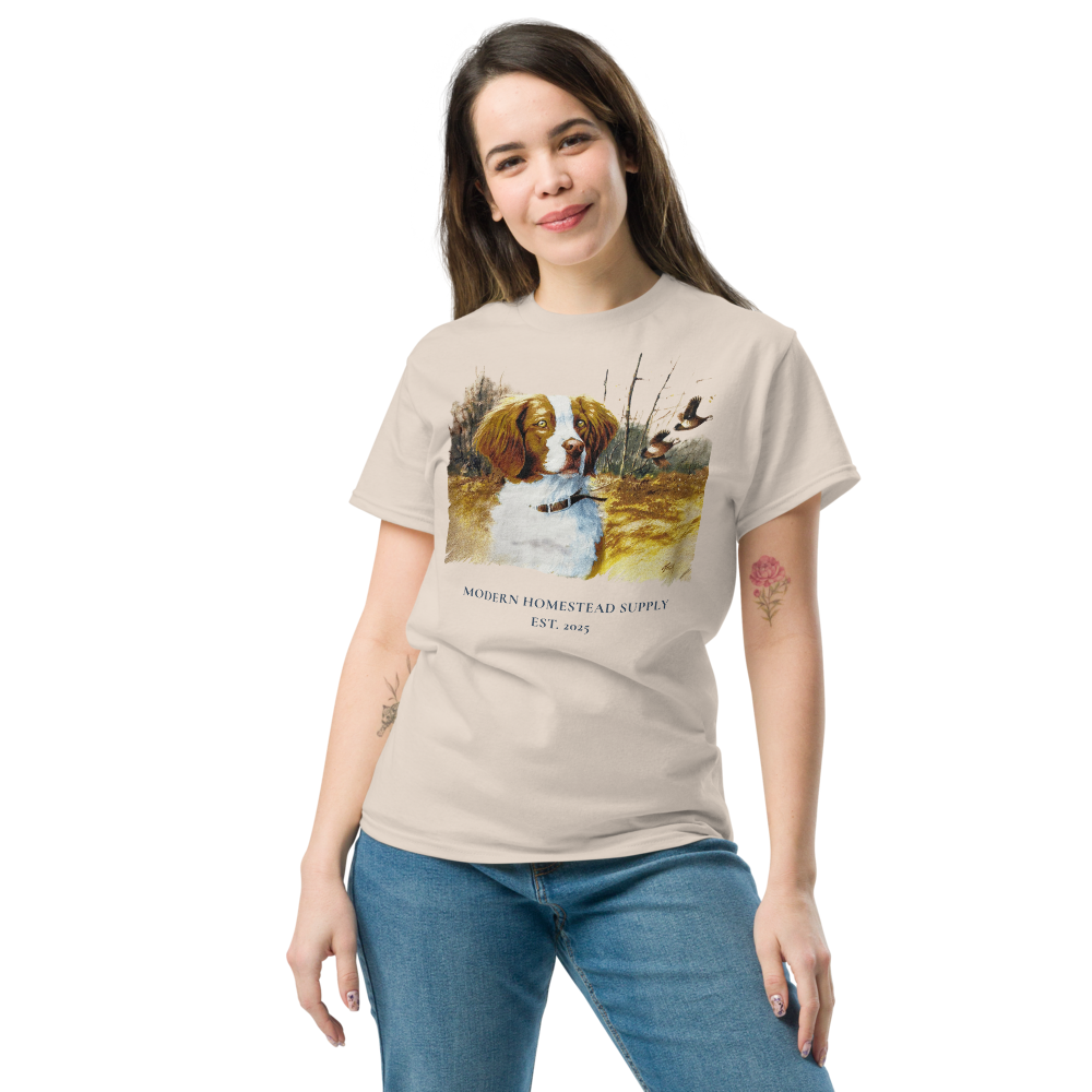 Woman wearing a beige t-shirt with a nature-themed graphic and text, standing against a white background.